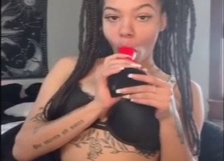 Ebony girl sucking off a red rocket dildo